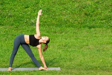 Woman on a yoga, relax in the park.