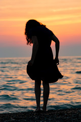 female silhouette at sunset sea