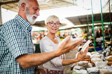Fototapeta na wymiar Portrait of beautiful elderly couple in market buing food