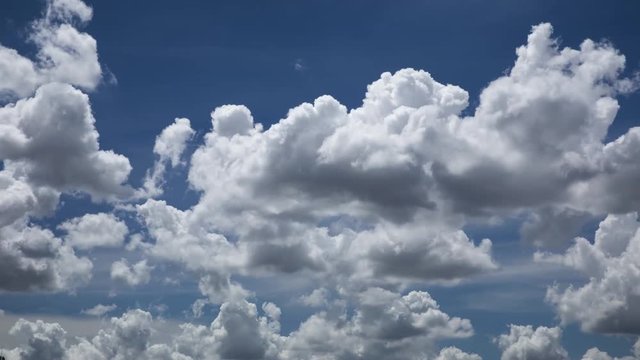 time lapse of puffy, fluffy white tropical cumulus clouds moving from left to right. Background is brilliant blue sky. The mood is positive.