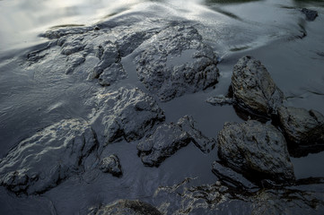 Oil sludge contaminating the sea during the oil spill disaster in Samet Island, Rayong, Thailand.