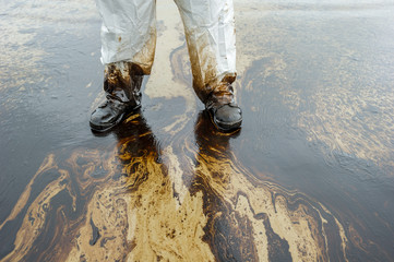 Petroleum spill mixed with other chemical substances on sea and sand surface. Pollution images,...