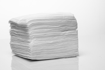 A stack of new white paper napkins on a white background