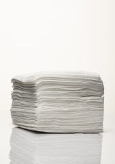 A stack of new white paper napkins on a white background