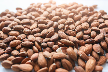 Almond nuts lying on white background. Healthy food. Vegan concept. Lifestyle. Vertical.