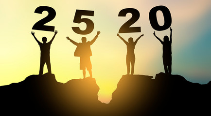 Group of people on mountains top in winner pose. Happy new year 2520 Concept