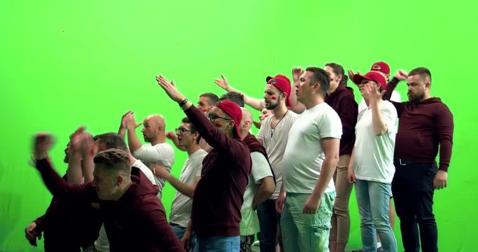 GREEN SCREEN CHROMA KEY 3/4 view group of people fans wearing red clothes are outraged during a sport event. 4K UHD ProRes 422 HQ