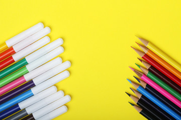 Multicolored markers and pencils at bright background