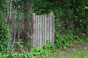 Fototapeta premium Countryside view of old wood fence doors near metal fence.
