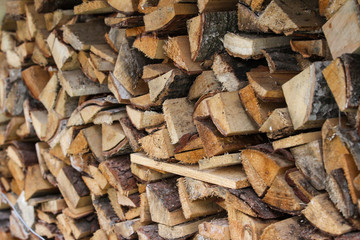 Beautiful countryside view of timber firewood stacked in a big stack near home in a countryside village home. 