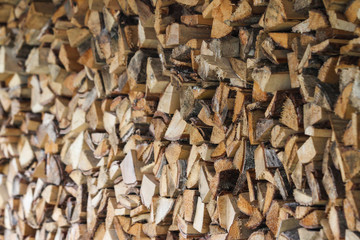 Beautiful countryside view of timber firewood stacked in a big stack near home in a countryside village home. 