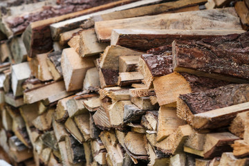 Beautiful countryside view of timber firewood stacked in a big stack near home in a countryside village home. 