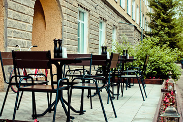 European cozy street cafe waiting for visitors. Outdoor empty cafe.