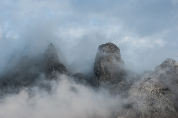 Mountain cloud top view landscape. Peak covered in Clouds. Massive Mountains of limestone in bad weather. Cloudy sky.