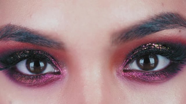 Professional makeup. Close up of a eyes models with glitter on the eyelids. Fashion eyes makeup