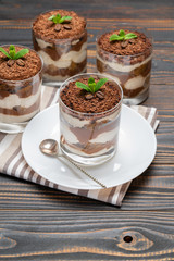Classic tiramisu dessert in a glass on wooden background