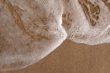Wet sand and sea foam background