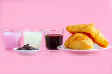 croissants served with glass of Fresh milk, coffee on pink background. Breakfast concept.