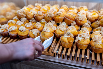 Closeup of human hand picking meat floss muffin by clamp