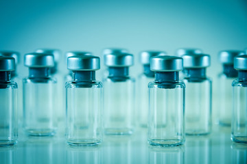 Vaccine glass bottles on blue background