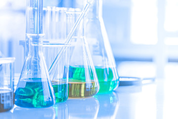 Different laboratory glassware with color liquid and with reflection. Tube, flask and beaker