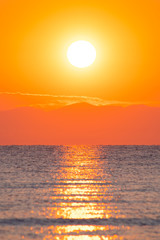 Fototapeta na wymiar Sunrise / sunset at the sea with sun in the background