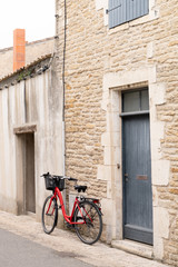 Fototapeta na wymiar Isle of Re old stone house with grey shutters and bike in France