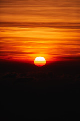 Sunrise / sunset over the clouds and horizon in golden colors.