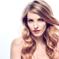Fototapeta premium Portret kobiety moda uroda. Zmysłowa młoda blondynka z modną falującą fryzurą zdrową skórę, makijaż. Piękna uśmiechnięta dziewczyna pozytywny model, modna stylizacja kręcone włosy. Koncepcja makijażu produktów do pielęgnacji skóry