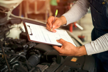 Professional Mechanic Repairing Car Engine with wrench  in auto repair service.