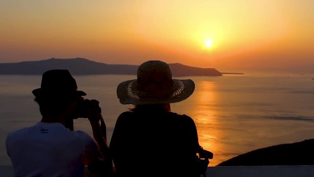 Sunset in Greece Santorini sky red sky white roofs Church people back hat sun photo