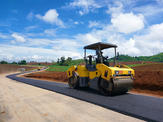 Road rollers building the new asphalt road and working on new road construction site.