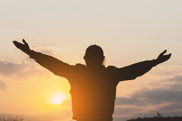 Fototapeta premium silhouette of a man extend the arms in the nature with happy.