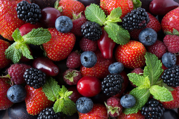 Obraz premium Ripe strawberries, blackberries, blueberries, raspberries, red berries abd plum. Mix berries and fruits. Top view. Background berries and fruits. Black-blue and red berries and fruits.