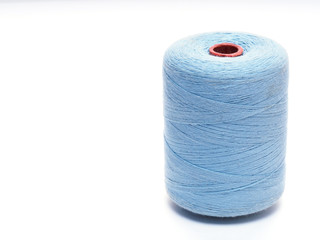 Blue spool of thread in a vertical position on a white background