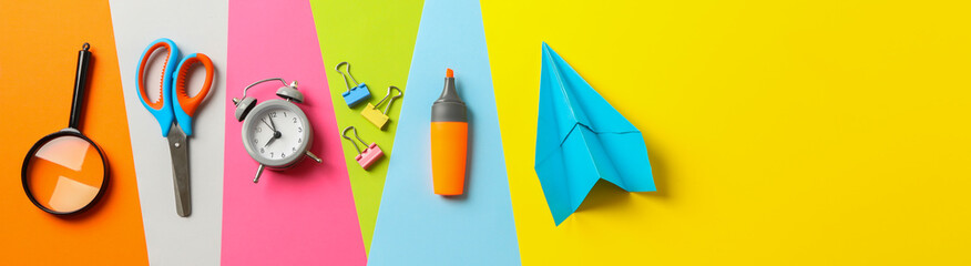 Flat lay composition with school supplies on multicolor background, space for text