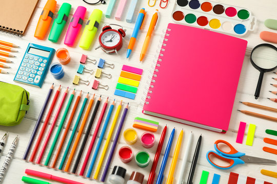 Flat lay composition with school supplies on white wooden background