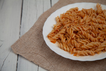 white plate with pasta on a wooden table