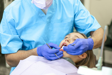 Dental clinic. Reception, examination of the patient. Teeth care. Young woman undergoes a dental examination by a dentist