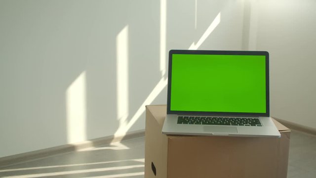 Closeup shoot of laptop with green chroma key screen laying on the box in the office indoors
