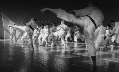 Kids training on karate-do. Banner with space for text. For web pages or advertising printing. Black and white photo without faces.