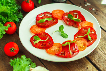 tomatoes salad with sunflower seedlings microgreen (carpaccio, sliced ​​raw vegetables). food background. top view. copy space