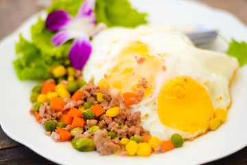 fried egg with bacon and vegetables on white plate