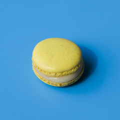 Yellow macaroon on blue background