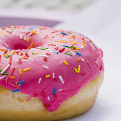 Macro shot of donut with cream and colorful sprinkles