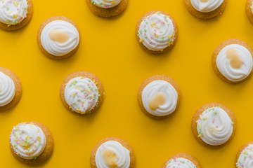 Whipped cream over cupcake on an yellow background