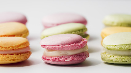 Fresh delicious macaroons on white backdrop