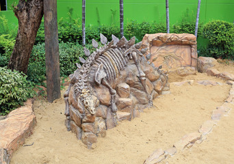 Replica dinosaur fossil on the sand ground