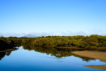 Landscape of Urunga Lagoon, with mountain in the background.