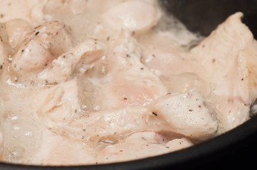 The process of cooking chicken breast diet for an athlete in a frying pan in sunflower oil. Meat for muscle recovery after exercise.